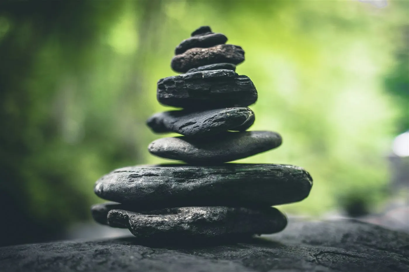 Balanced stones stacked against a green background